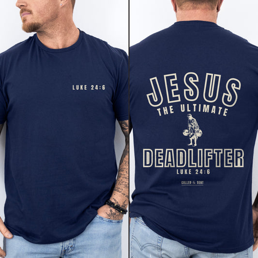 Jesus The Ultimate Deadlifter Christian shirt, Navy, worn by a man, front chest verse badge with collegiate JESUS THE ULTIMATE DEADLIFTER back print, Luke 24:6