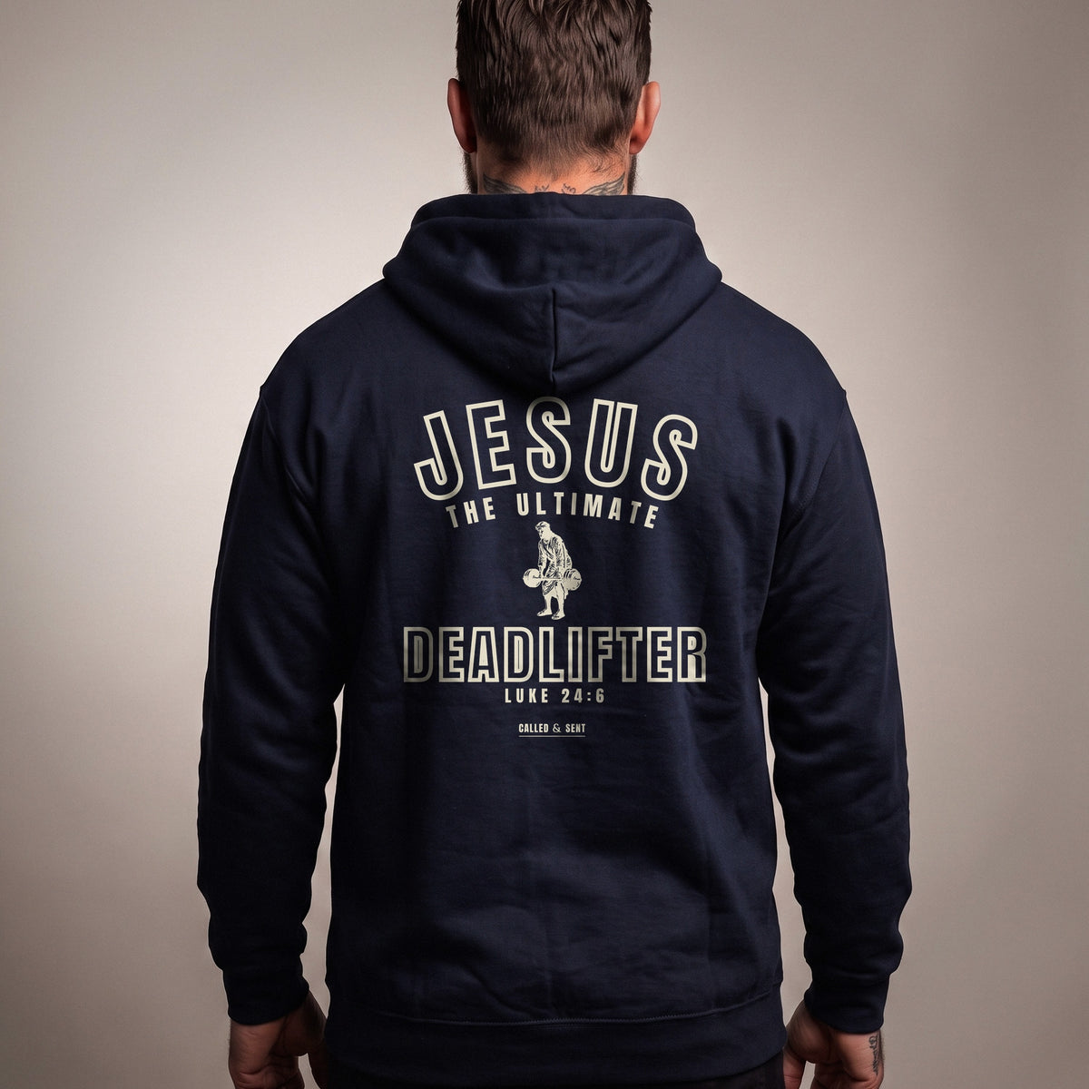 Jesus the Ultimate Deadlifter Christian hoodie, Navy, worn by a man, back view, Luke 24:6 back print