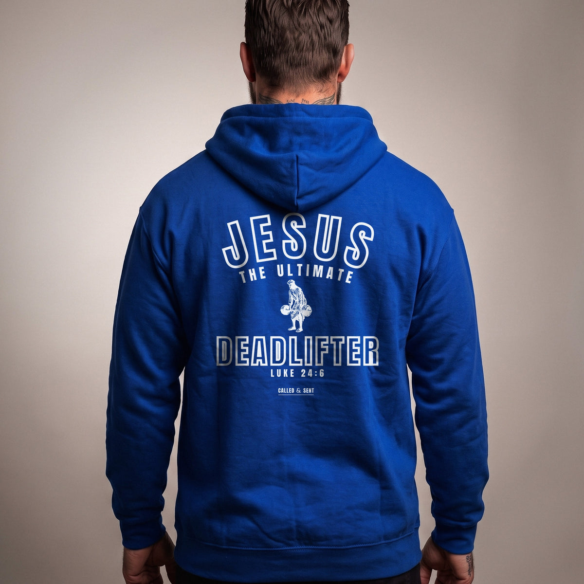 Jesus the Ultimate Deadlifter Christian hoodie, Royal Blue, worn by a man, back view, Luke 24:6 back print in white ink