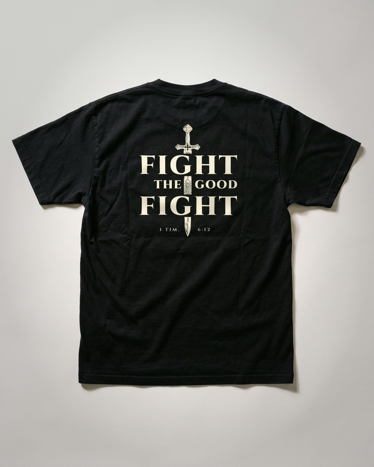 Fight The Good Fight heavyweight tee flat lay of the back print shown on an XL, 1 Timothy 6:12, Black