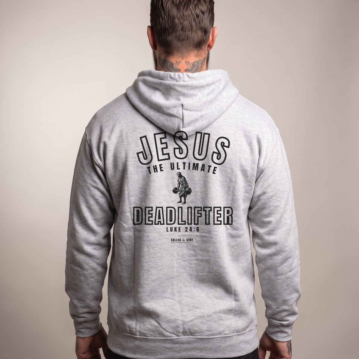 Jesus the Ultimate Deadlifter Christian hoodie, Sport Grey heather, worn by a man, back view, Luke 24:6 back print in dark ink